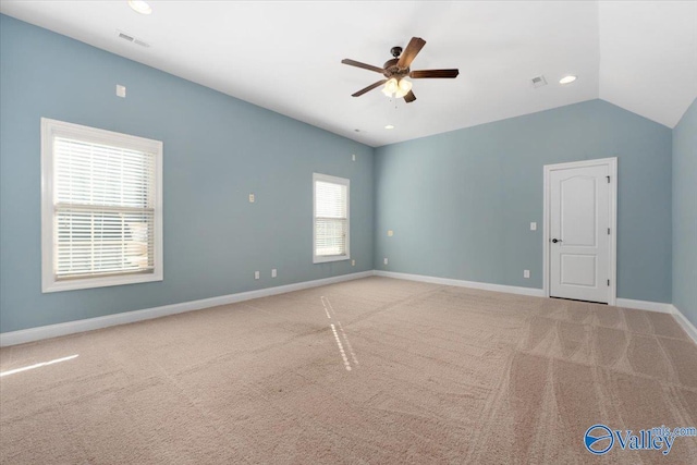 carpeted spare room with ceiling fan and vaulted ceiling