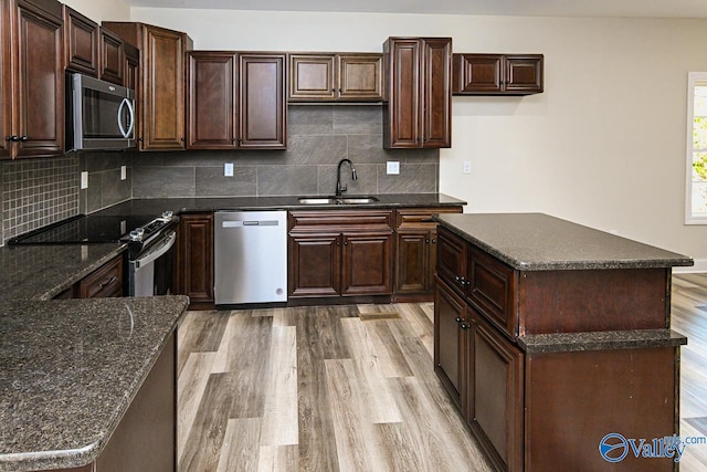 kitchen with decorative backsplash, sink, stainless steel appliances, and light wood-type flooring