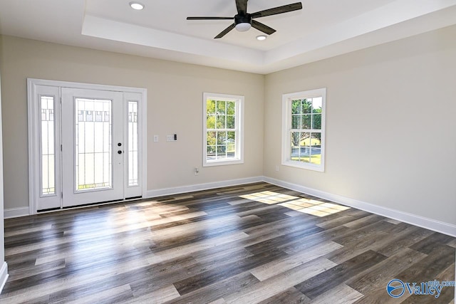 foyer entrance with dark hardwood / wood-style flooring, a tray ceiling, and ceiling fan