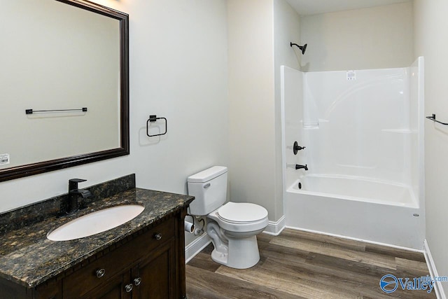 full bathroom with hardwood / wood-style floors, vanity, bathtub / shower combination, and toilet