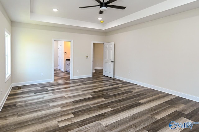 unfurnished bedroom featuring multiple windows, dark hardwood / wood-style floors, and ensuite bathroom