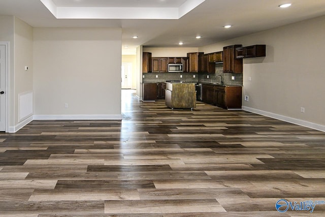 kitchen with dark brown cabinetry, dark hardwood / wood-style flooring, a center island, and appliances with stainless steel finishes