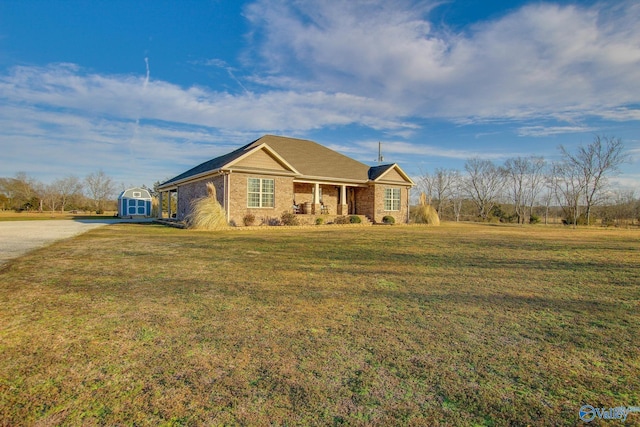 ranch-style house with a storage shed, a front yard, and covered porch