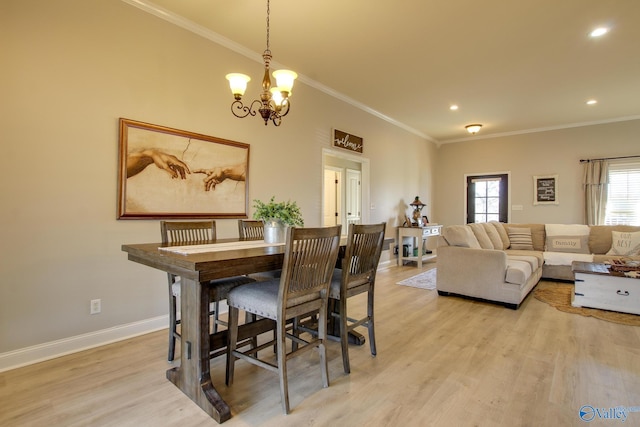 dining area featuring an inviting chandelier, crown molding, and light hardwood / wood-style floors