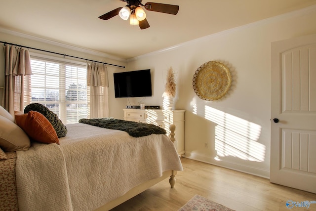 bedroom featuring crown molding, light hardwood / wood-style flooring, and ceiling fan