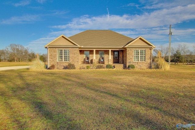 ranch-style house with a front yard and covered porch