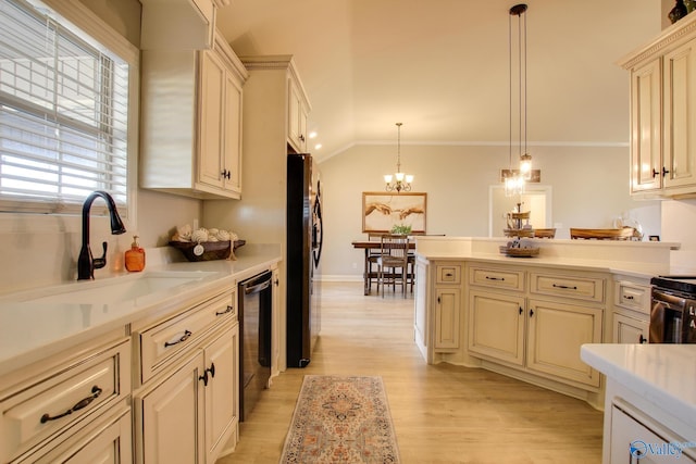 kitchen featuring pendant lighting, sink, black refrigerator, ornamental molding, and cream cabinetry