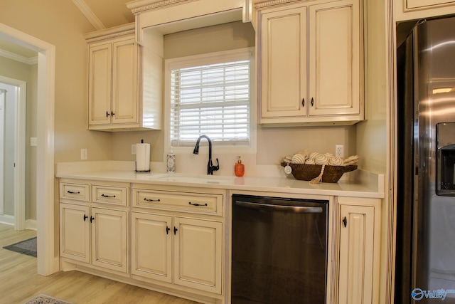 kitchen featuring cream cabinets, crown molding, light hardwood / wood-style flooring, and stainless steel appliances