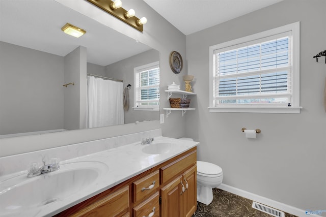 bathroom featuring vanity, toilet, and walk in shower