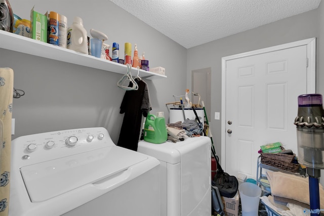 laundry area featuring water heater, a textured ceiling, and independent washer and dryer