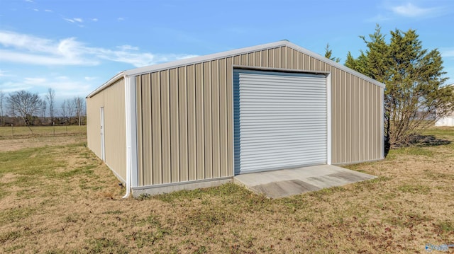 view of outdoor structure featuring a lawn and a garage