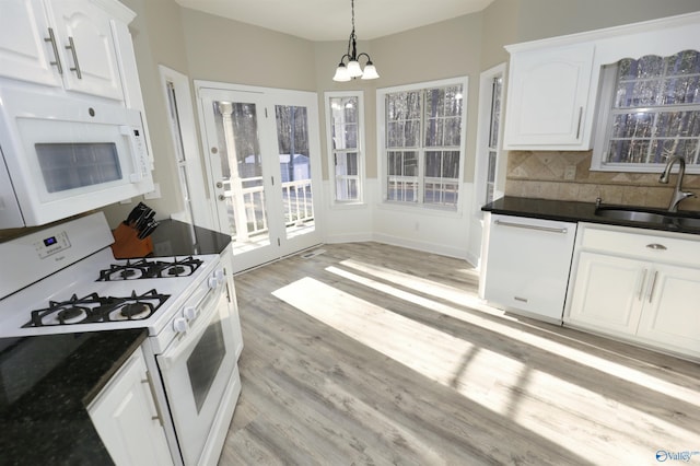 kitchen with sink, white appliances, light hardwood / wood-style flooring, white cabinetry, and hanging light fixtures