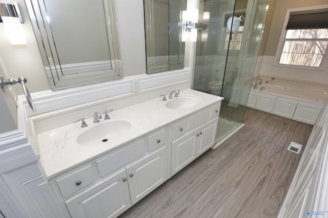 full bathroom featuring hardwood / wood-style flooring, vanity, toilet, and independent shower and bath