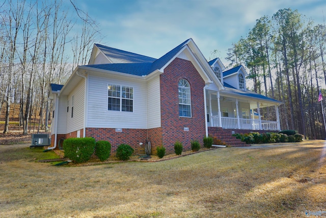 view of front of home with central AC unit, a front yard, and a porch