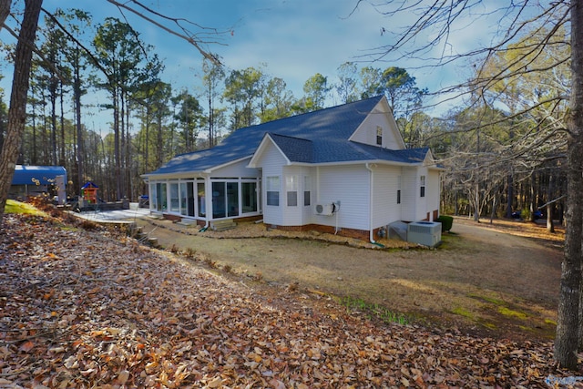 rear view of property featuring central AC unit and a sunroom