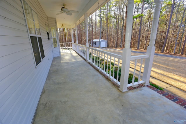 view of patio / terrace featuring a porch, ceiling fan, and a storage unit