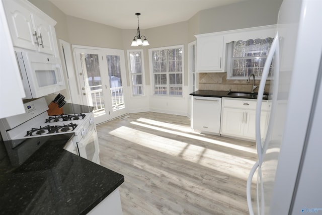 kitchen featuring sink, white appliances, light hardwood / wood-style floors, white cabinets, and decorative light fixtures