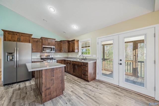 kitchen featuring a kitchen island, lofted ceiling, stainless steel appliances, and french doors