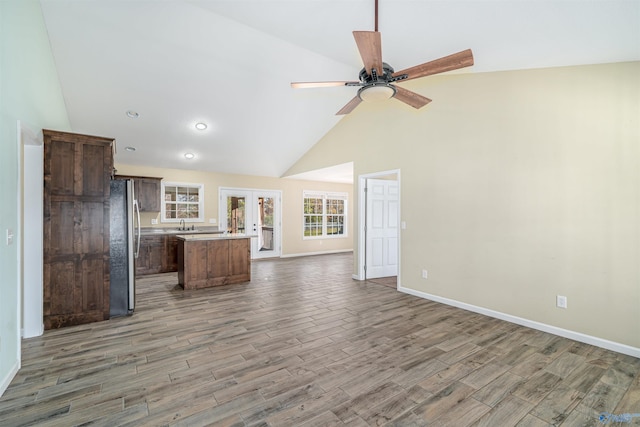 unfurnished living room with ceiling fan, french doors, high vaulted ceiling, and dark hardwood / wood-style floors