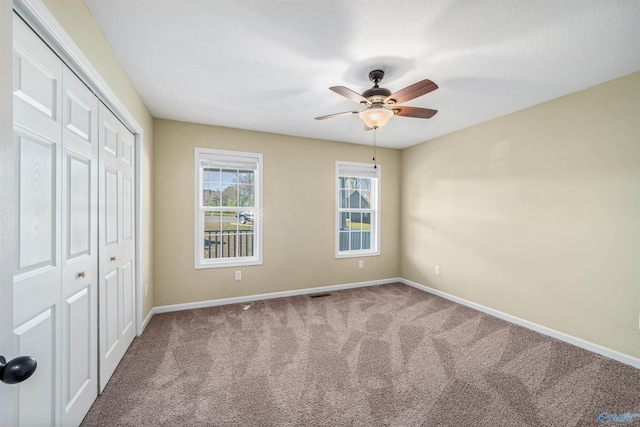 unfurnished bedroom with carpet flooring, ceiling fan, and a closet