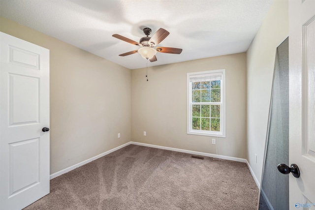 spare room featuring carpet, ceiling fan, and a textured ceiling