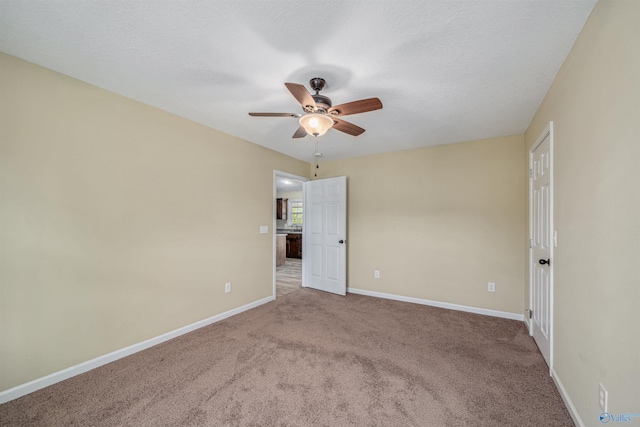 empty room with ceiling fan, carpet, and a textured ceiling