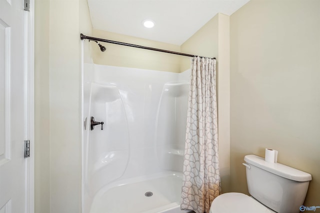 bathroom with a shower with curtain and toilet