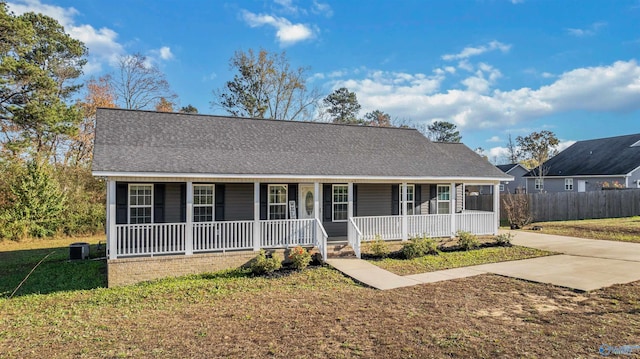 ranch-style house with a porch, a front lawn, and central air condition unit