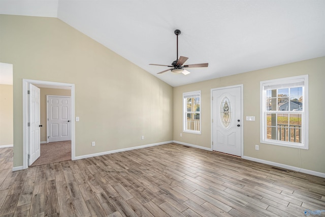 entryway with a healthy amount of sunlight, lofted ceiling, and light hardwood / wood-style flooring