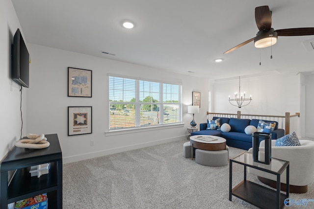 carpeted living room with ceiling fan with notable chandelier