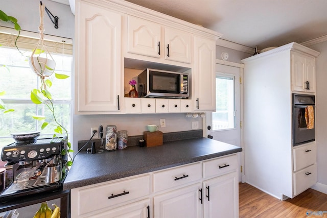 610 Grover Davis Rd, Hamilton, AL 35570 - kitchen with stainless steel microwave, oven, dark countertops, ornamental molding, and light wood-style floors