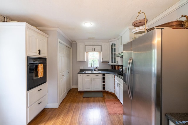 610 Grover Davis Rd, Hamilton, AL 35570 - kitchen with black appliances, a sink, dark countertops, light wood-style flooring, and white cabinetry