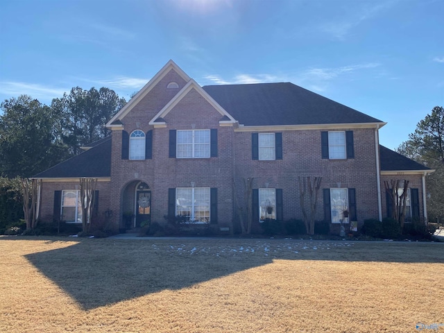 view of front facade featuring brick siding and a front yard