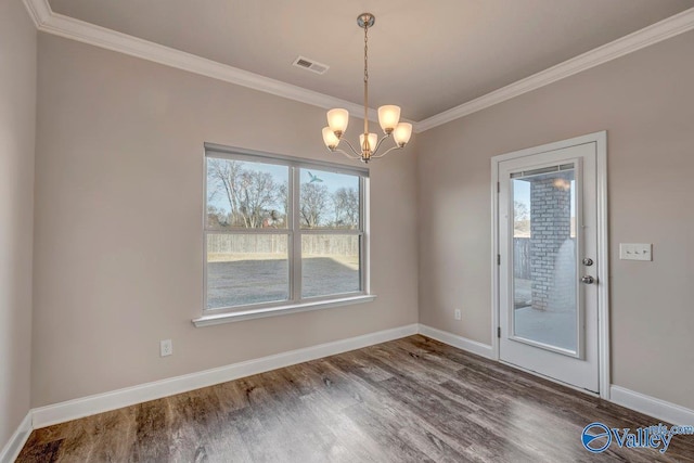 unfurnished dining area featuring ornamental molding, hardwood / wood-style floors, and a chandelier