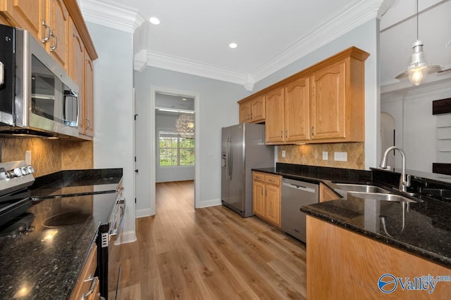 kitchen featuring recessed lighting, stainless steel appliances, a sink, light wood-style floors, and dark stone counters
