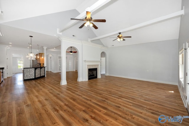 unfurnished living room featuring baseboards, a ceiling fan, beam ceiling, and hardwood / wood-style floors