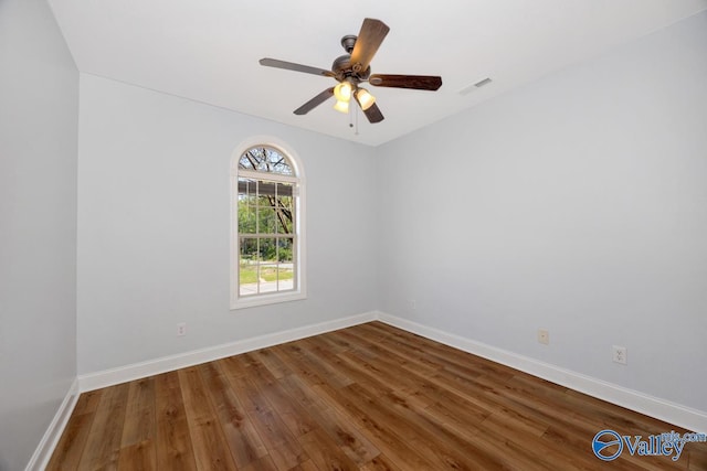 unfurnished room featuring wood finished floors, visible vents, baseboards, and ceiling fan