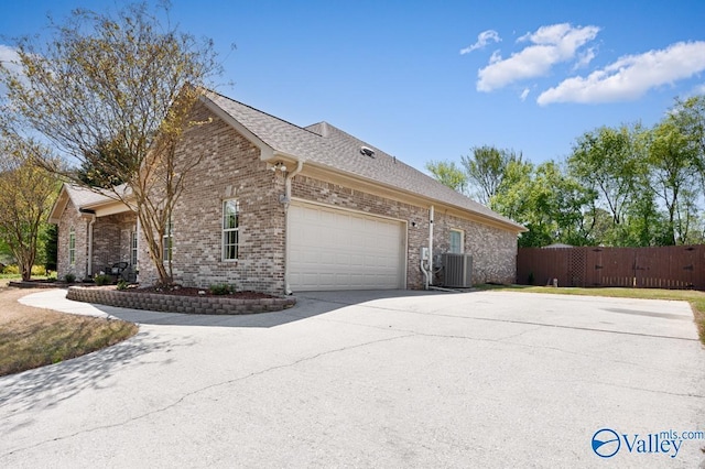 view of home's exterior with concrete driveway, an attached garage, fence, cooling unit, and brick siding