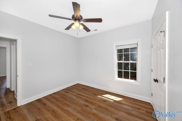 unfurnished room featuring hardwood / wood-style floors, baseboards, ceiling fan, and visible vents