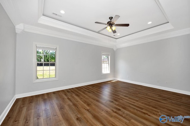 unfurnished room with visible vents, a tray ceiling, ornamental molding, and a healthy amount of sunlight