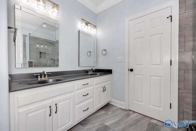 full bathroom with double vanity, a sink, ornamental molding, and a tile shower