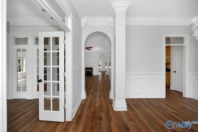 hallway featuring french doors, dark wood-style floors, arched walkways, and crown molding