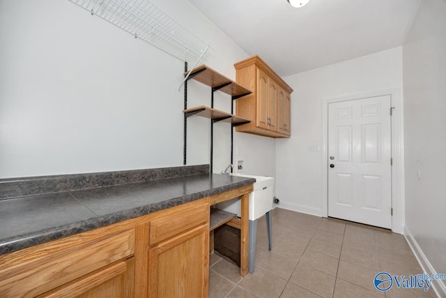 laundry room featuring light tile patterned floors, baseboards, cabinet space, and washer hookup