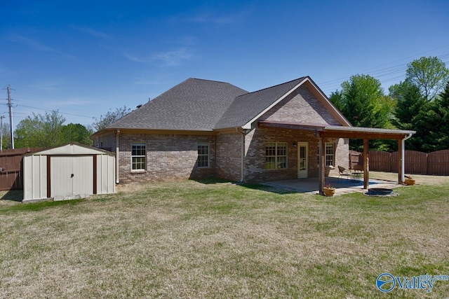 rear view of property with a fenced backyard, brick siding, a yard, a shed, and a patio