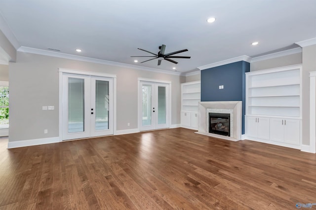 unfurnished living room with french doors, a high end fireplace, hardwood / wood-style flooring, and ornamental molding