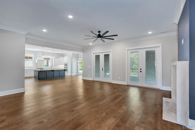 unfurnished living room featuring crown molding, french doors, dark hardwood / wood-style flooring, and ceiling fan