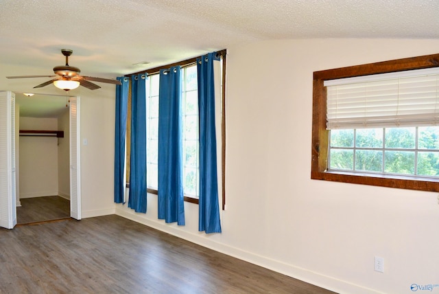 spare room with a textured ceiling, wood-type flooring, and vaulted ceiling