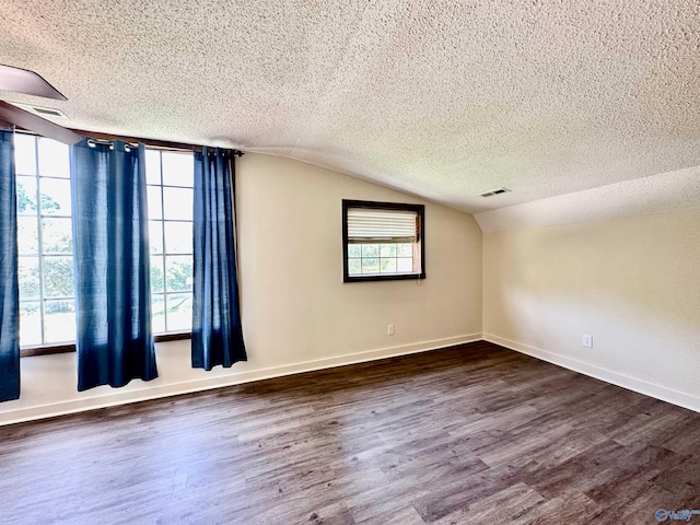 unfurnished room featuring hardwood / wood-style flooring, lofted ceiling, and a textured ceiling