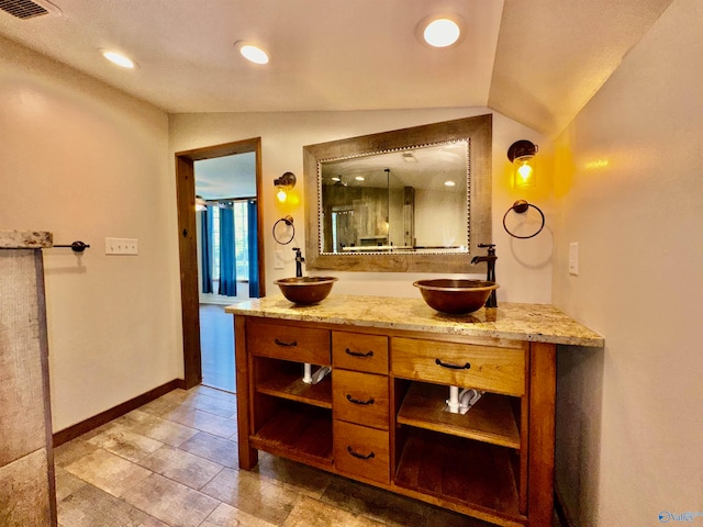 bathroom featuring tile patterned flooring, lofted ceiling, and vanity