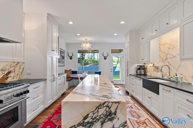 kitchen with dark wood-style floors, white cabinets, and stainless steel range